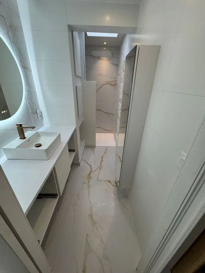 Salle de bain rénovée à Vannes avec carrelage effet marbre, vasque blanche, mitigeur et miroir LED